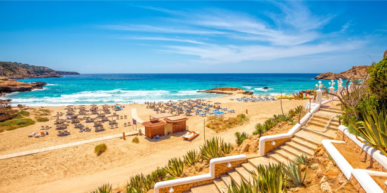 Accès à la plage de Cala Tarida, avec transats dans le sable