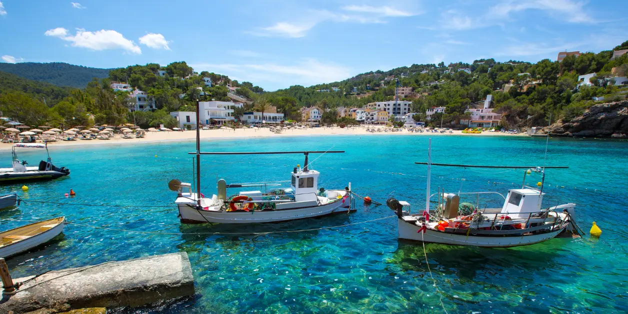 Fiskebåter i det krystallklare vannet i Cala Vadella